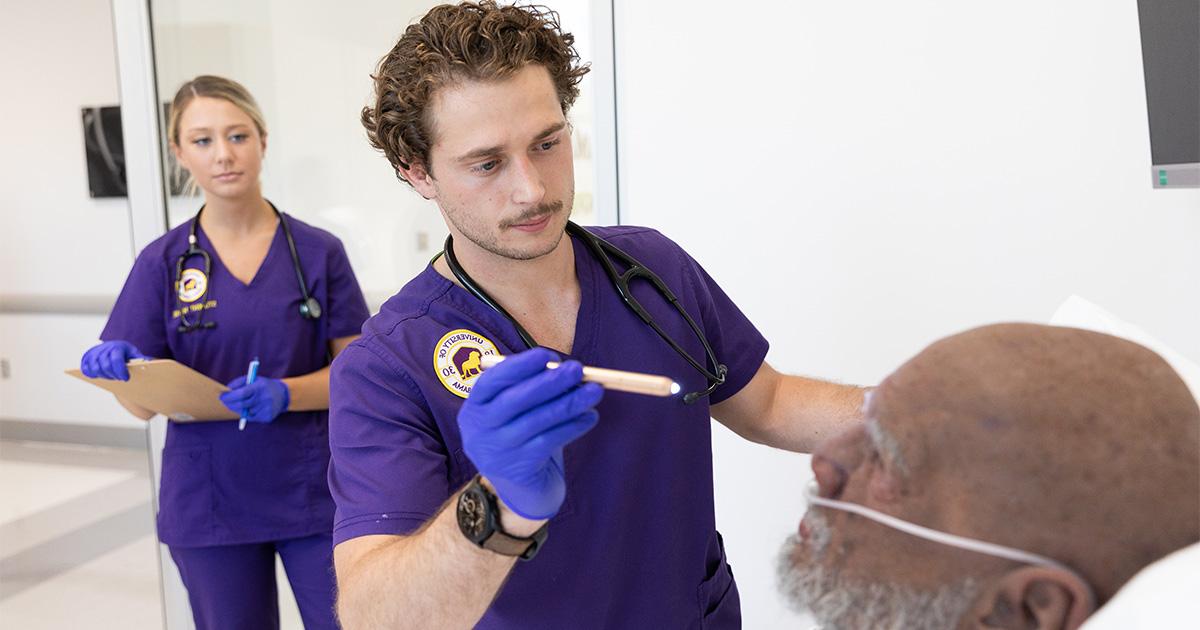 Students are able to use the simulation lab in Harrison Hall. Here, a man and woman in the nursing program run tests on a simulation person.